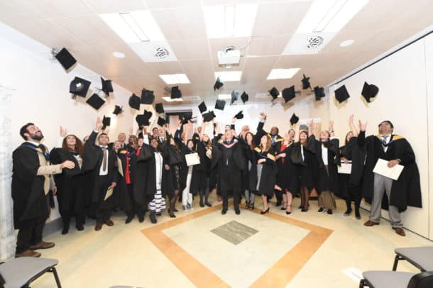 graduates of rome business school tossing their caps